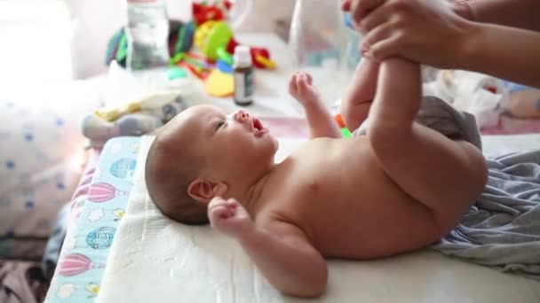 Orvosi fogalmak - anyai kéz ad neki újszülött gyermek masszázs lábon otthon belül — Stock videók