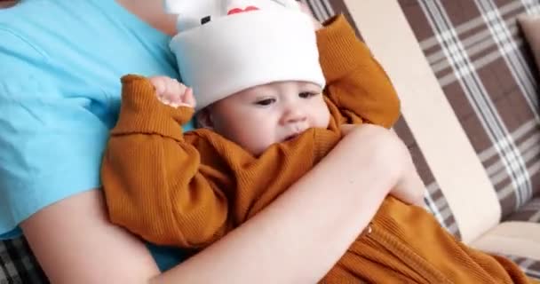 Bonne famille ensemble sur un jardin balancer une journée d'été ensoleillée. Une mère attentionnée tient son jeune fils dans ses bras — Video