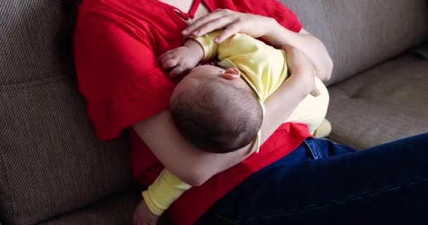 Mother breastfeeding baby and kissing her. Cheerful mom enjoy breastfeeding at home. motherhood and maternity care concept — Stock Video