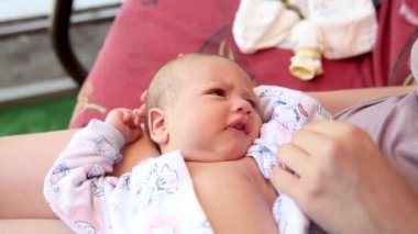 Ebeveynler yeni doğmuş küçük çocukla oynuyorlar. Onu kollarında tutuyorlar.