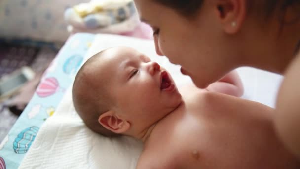 Genç annenin otantik yakın çekimi yeni doğmuş bebeğiyle oynayıp öpüşmesi. Annelik kavramı — Stok video