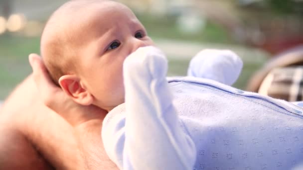 Genitori giocano con il neonato bambino tenendolo tra le braccia da vicino — Video Stock