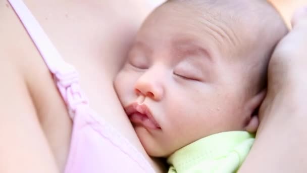 Little baby boy sleeping on moms chest outdoor. mother hugging sleeping baby in her arms and kissing the kid gently — Stock Video