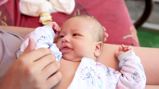 Родители играют с новорожденным ребенком, держа его на руках. — стоковое видео