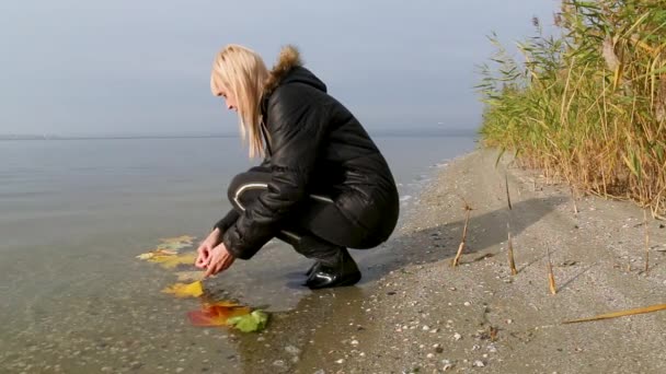 Gelborange Ahorn- und Eichenblätter liegen im Wasser. Herbstliches Laub fließt den Fluss hinunter — Stockvideo