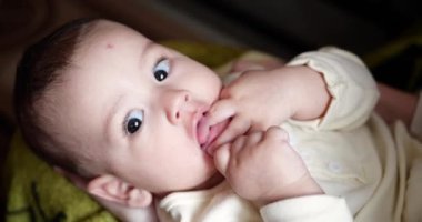 Küçük mutlu çocuk bacaksız anne eliyle oynuyor. Isır ve ayak parmaklarını em. 4K