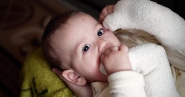 Küçük mutlu çocuk bacaksız anne eliyle oynuyor. Isır ve ayak parmaklarını em. 4K