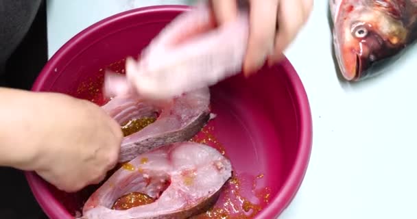 Marynowana ryba z przyprawami. Przed gotowaniem, ręka kucharza rozmazuje masło i przyprawy. koncepcja gotowania domowego — Wideo stockowe