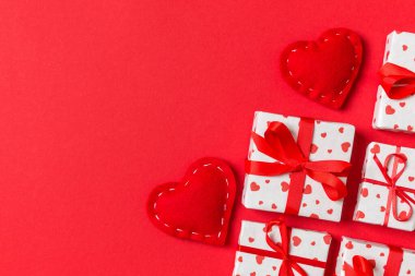 Renkli arka planda hediye kutularının ve kırmızı tekstil kalplerinin tatil kompozisyonu ve tasarımınız için boş alan. Sevgililer Günü konseptinin en üst görüntüsü.