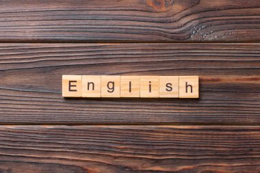 Tahta bloğa yazılmış İngilizce kelime. Deksing, konsept için çimento üzerinde İngilizce metin.