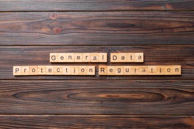 Tahta blokta GDPR kelimesi yazıyor. Genel Veri Koruma Yönetmeliği metni desing, konsept için çimento tablo üzerinde.