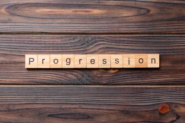 Tahta bloğa yazılmış bir kelime. desing, konsept için beton tablo üzerindeki ilerleme metni.