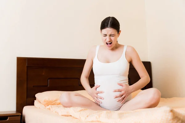 Joven Mujer Embarazada Bonita Con Dolor Sentada Cama Dormitorio Preparándose —  Fotos de Stock