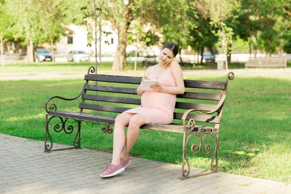 Mulher Grávida Senta Banco Parque Escreve Uma Lista Fazer Para — Fotografia de Stock