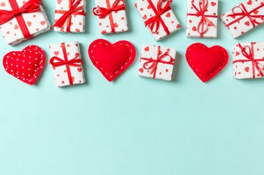 Hediye kutularının ve renkli arka planda kırmızı tekstil kalplerinin üst görüntüsü. Kopya alanı ile Sevgililer Günü konsepti.