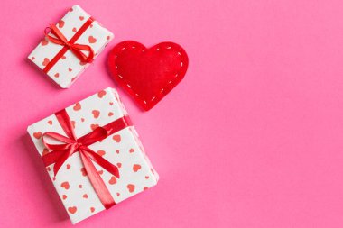 Hediye kutuları ve kırmızı tekstil kalplerden yapılmış üst görünüm renkli sevgililer günü arkaplanı. Kopya alanlı Sevgililer Günü konsepti.