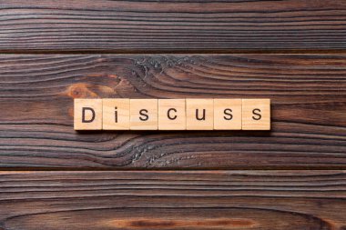 Tahta blokta yazan kelimeleri tartışın. Deksing, konsept için çimento masadaki metni tartışın.