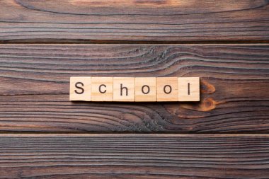 Tahta bloğa yazılmış okul kelimesi. Okul metni çimento üzerinde desing, konsept için.