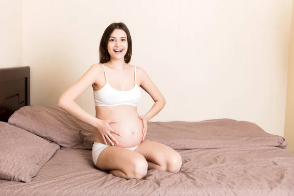 Mujer Embarazada Sentada Cama Tocándose Vientre Casa Concepto Expectativa Embarazo — Foto de Stock