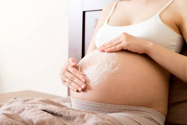 Uma Menina Grávida Senta Casa Cama Mancha Creme Marca Estiramento — Fotografia de Stock