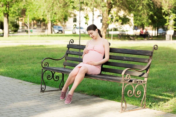 一个怀孕的年轻女子坐在公园的长椅上 怀孕和做母亲 健康的生活方式 — 图库照片