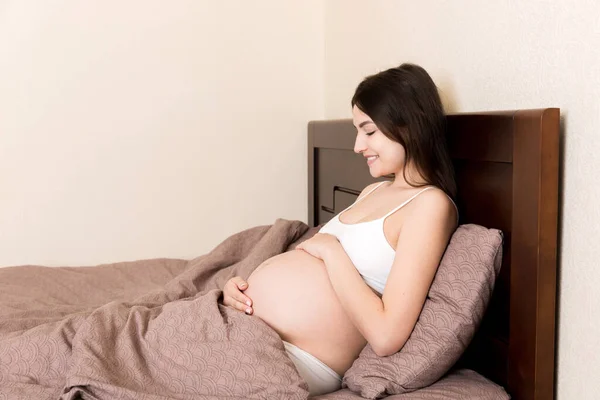 Mujer Embarazada Sentada Cama Tocándose Vientre Casa Concepto Expectativa Embarazo —  Fotos de Stock