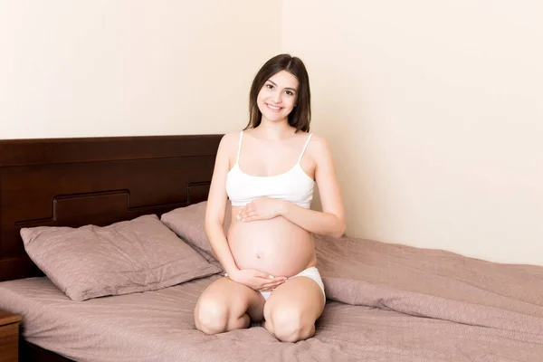 Ciężarna Kobieta Siedząca Łóżku Dotykająca Brzucha Domu Koncepcja Spodziewanej Ciąży — Zdjęcie stockowe
