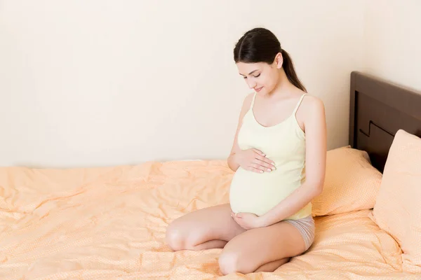 Mujer Embarazada Sentada Cama Tocándose Vientre Casa Concepto Expectativa Embarazo — Foto de Stock