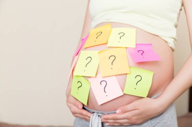 Soru işaretli hamile kadın göbeği. Hamilelik ve düşünme problemi.