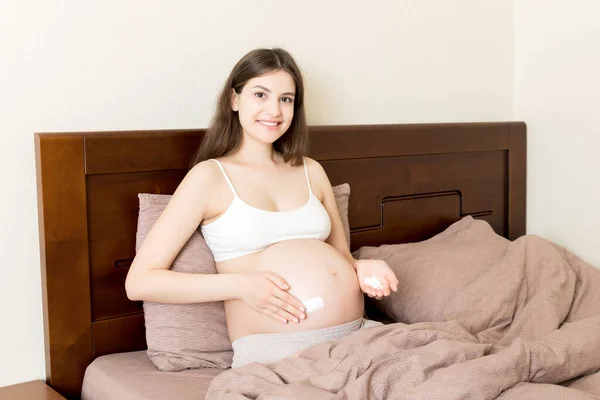 Gravid Flicka Sitter Hemma Sängen Och Smetar Stretch Märke Grädde — Stockfoto