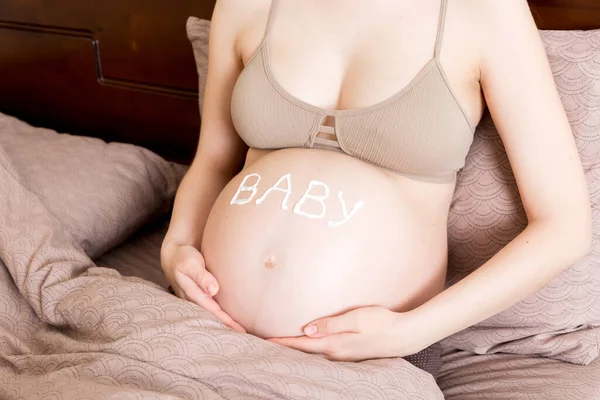 Hamile Bir Kız Evde Yatağında Oturuyor Karnına Esneme Önleyici Krem — Stok fotoğraf