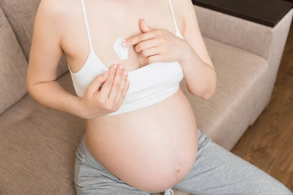 孕妇在腹部涂伸展标记霜 人和生育的概念 怀孕期间在她的乳房上涂抗拉伸标记霜 — 图库照片