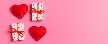 Renkli arka planda hediye kutularının ve kırmızı tekstil kalplerinin tatil kompozisyonu ve tasarımınız için boş alan. Sevgililer Günü konseptinin en üst görüntüsü.