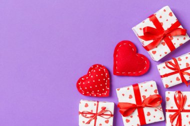 Hediye kutuları ve kırmızı tekstil kalplerden yapılmış üst görünüm renkli sevgililer günü arkaplanı. Kopya alanlı Sevgililer Günü konsepti.