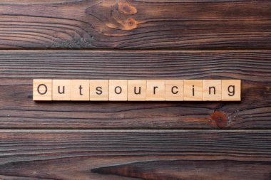 Tahta blokta yazan taşeronluk kelimesi. Tablo üzerinde taşeron metin, kavram.