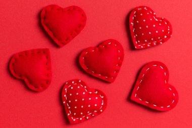 Renkli arka planda tekstil kırmızısı kalplerin bileşimi. Manzarayı kapat. Sevgililer Günü konseptinin en üst görüntüsü.