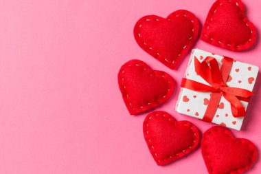 Hediye kutularının ve renkli arka planda kırmızı tekstil kalplerinin üst görüntüsü. Kopya alanı ile Sevgililer Günü konsepti.