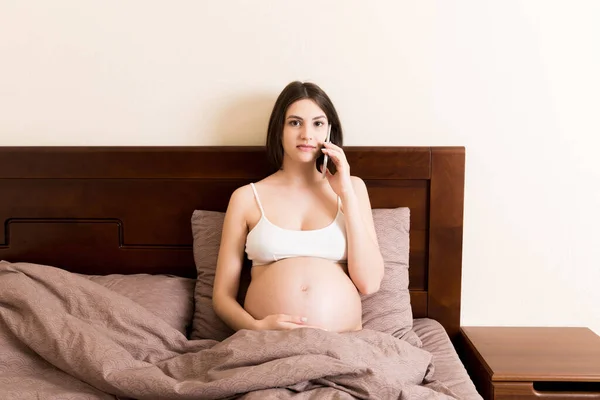 Donna Incinta Emotiva Che Parla Casa Con Cellulare Sul Letto — Foto Stock