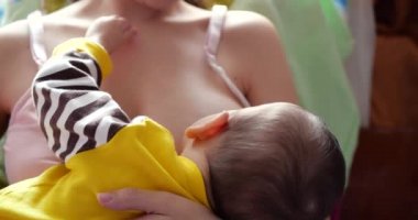 Anne yeni doğmuş bebeğini koltukta emziriyor. Anne sütü bebek için doğal bir ilaçtır. aile, yemek, çocuk, yeme ve ebeveynlik kavramı