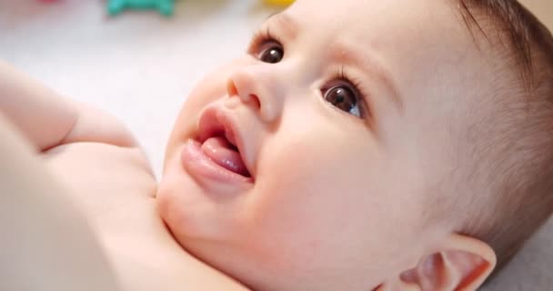 Милый маленький мальчик новорожденный ребенок портрет малыша улыбаясь в камеру глядя — стоковое видео