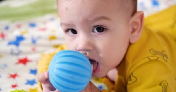Bebek, çocukluk konsepti. Gülümseyen mutlu bebeğin ip ile oynadığı yakın plan. Diş kesimi. İlk dişler. Neşesiz dişsiz 7 ay bebek ısırığı, kemiren oyuncak — Stok video