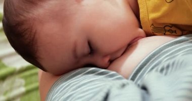 Anne yeni doğmuş bebeğini koltukta emziriyor. Anne sütü bebek için doğal bir ilaçtır. aile, yemek, çocuk, yeme ve ebeveynlik kavramı