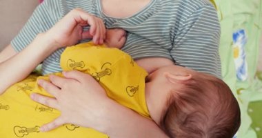 Anne yeni doğmuş bebeğini koltukta emziriyor. Anne sütü bebek için doğal bir ilaçtır. aile, yemek, çocuk, yeme ve ebeveynlik kavramı