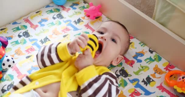 Zuigeling, kindertijd concept - close-up van lachende blije Baby speelt met een bijtring. Tanden knippen. Eerste tanden. Joy tandeloos 7 maanden baby beet, knagen bijtring speelgoed — Stockvideo