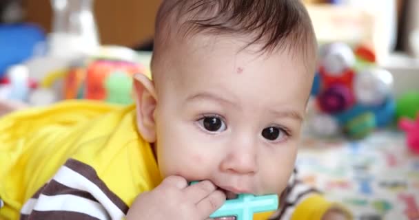婴儿，童年的概念- -笑着快乐婴儿的特写。切牙。第一颗牙快乐无牙7个月婴儿咬，咬牙切齿玩具 — 图库视频影像