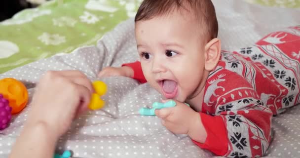 Zuigeling, kindertijd concept - close-up van lachende blije Baby speelt met een bijtring. Tanden knippen. Eerste tanden. Joy tandeloos 7 maanden baby beet, knagen bijtring speelgoed — Stockvideo