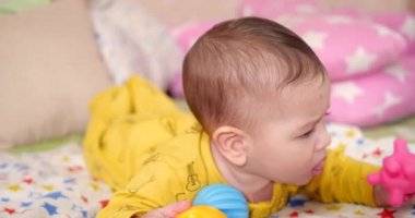 Bebek, çocukluk konsepti. Gülümseyen mutlu bebeğin ip ile oynadığı yakın plan. Diş kesimi. İlk dişler. Neşesiz dişsiz 7 ay bebek ısırığı, kemiren oyuncak