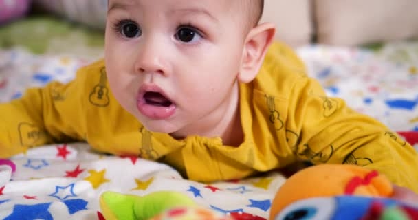 Spädbarn, barndomskoncept - närbild av leende glad baby leker med en teeter. Tänderna avskurna. De första tänderna. Glädje tandlös 7 månader baby bita, gnager teeter leksak — Stockvideo