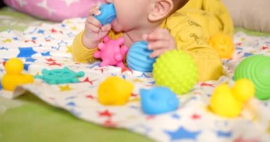 Bebek, çocukluk konsepti. Gülümseyen mutlu bebeğin ip ile oynadığı yakın plan. Diş kesimi. İlk dişler. Neşesiz dişsiz 7 ay bebek ısırığı, kemiren oyuncak