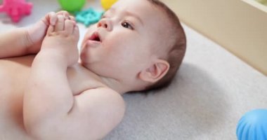 Bebek, çocukluk konsepti. Gülümseyen mutlu bebeğin ip ile oynadığı yakın plan. Diş kesimi. İlk dişler. Neşesiz dişsiz 7 ay bebek ısırığı, kemiren oyuncak